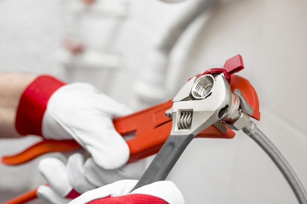 Plumber holding pipe wrenches for an emergency repair in Oviedo