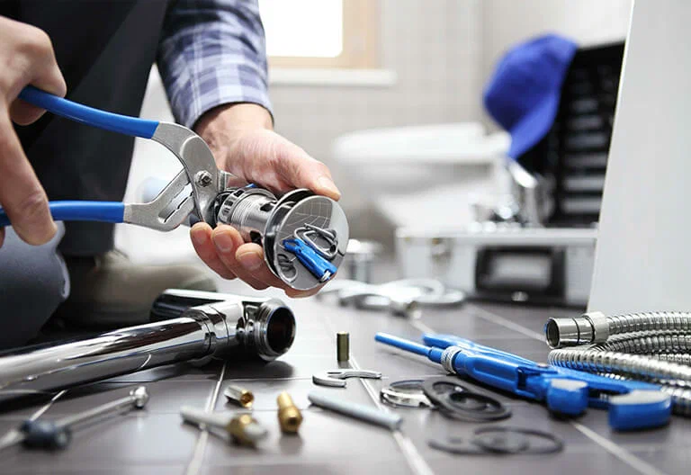 Technician repairing a plumbing fixture with professional tools in Oviedo
