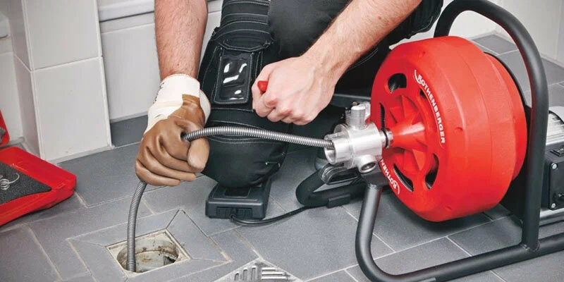 Plumber using a drain-cleaning machine in Oviedo
