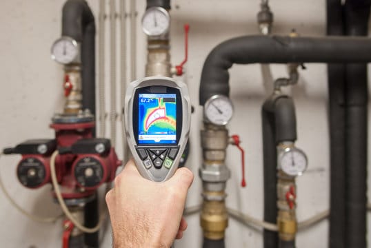 Plumber using a thermal imaging camera to inspect pipes in Oviedo